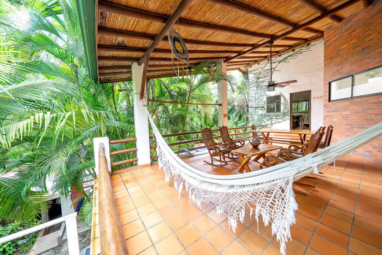 Hamaca y sillas de madera en la terraza de Dreamcatcher Villa